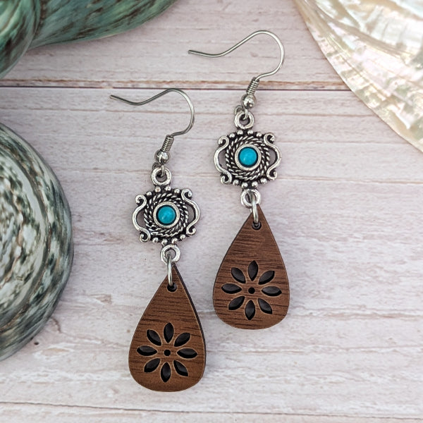 Wooden teardrop earrings with silver and turquoise accents on a light wooden surface. Stainless steel hooks.
