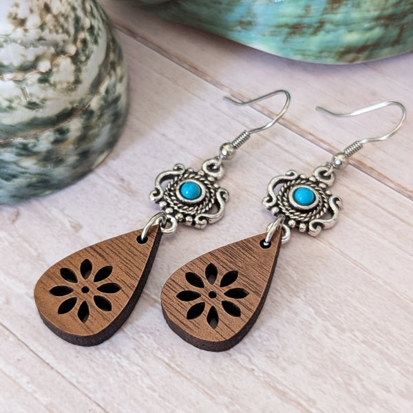 Wooden teardrop earrings with silver and turquoise accents on a light wooden surface. Stainless steel hooks.