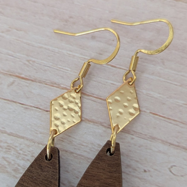 Wooden drop earrings with gold accents on a light wooden surface. Plated gold stainless steel hooks.
