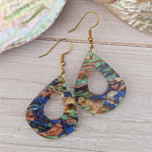 Teardrop-shaped earrings with multicolored pattern on a wooden surface