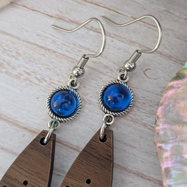 Pair of wooden and blue stone earrings on a wooden surface