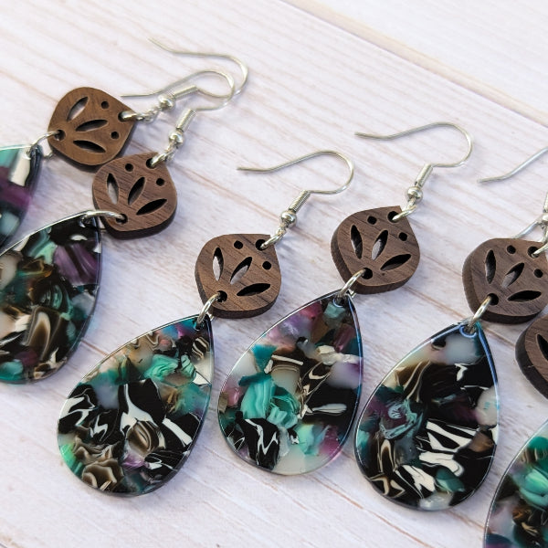 Colorful teardrop earrings with wooden accents on a light surface
