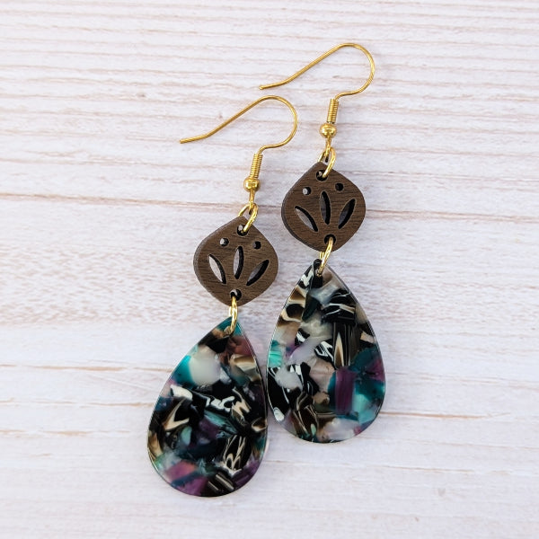 Pair of earrings with floral design on a light wooden surface