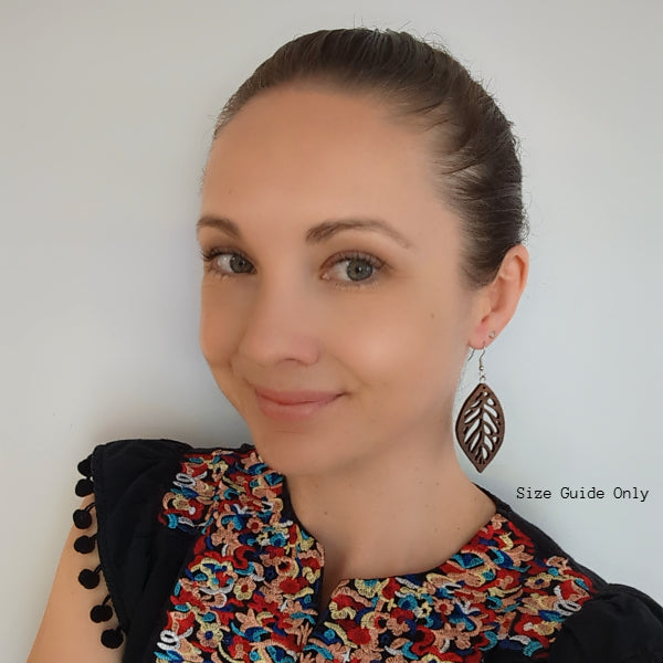 Women wearing wooden leaf shaped earrings.