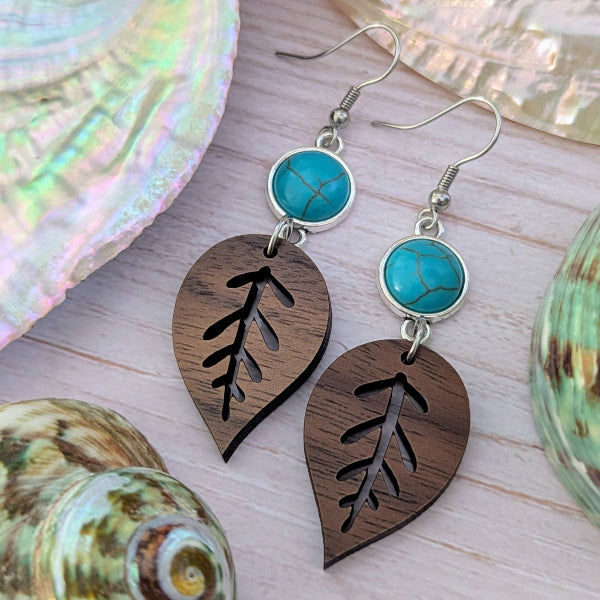 Wooden leaf-shaped earrings with turquoise stones on a shell background. Stainless steel hooks.