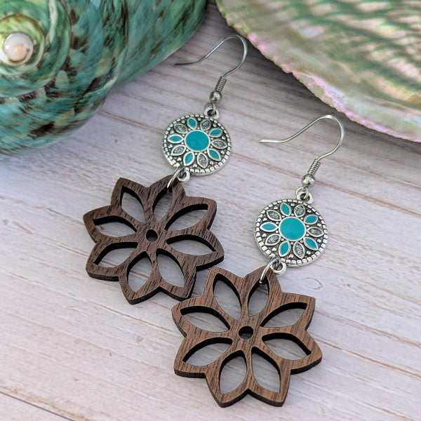 Wooden floral earrings with turquoise coloured enamel on a wooden surface. Stainless steel hooks.