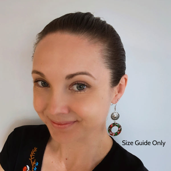 Woman wearing sunburst dangles as a size guide.
