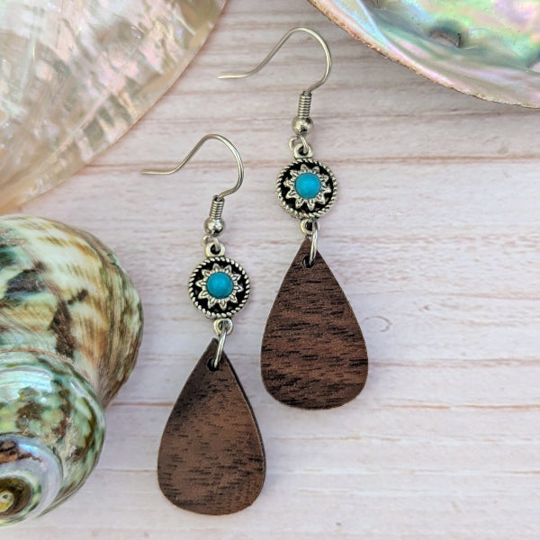 Wooden teardrop earrings with turquoise stones on a shell background. Stainless steel hooks.
