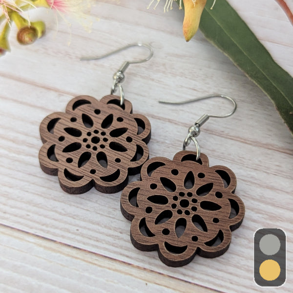 Wooden floral earrings on a light wooden surface with a natural background. Stainless steel hooks.