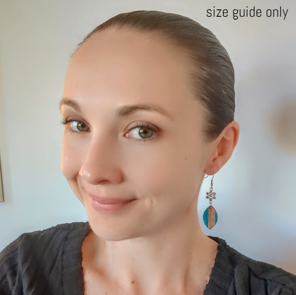 Women wearing seaside daisy earrings as a size guide.