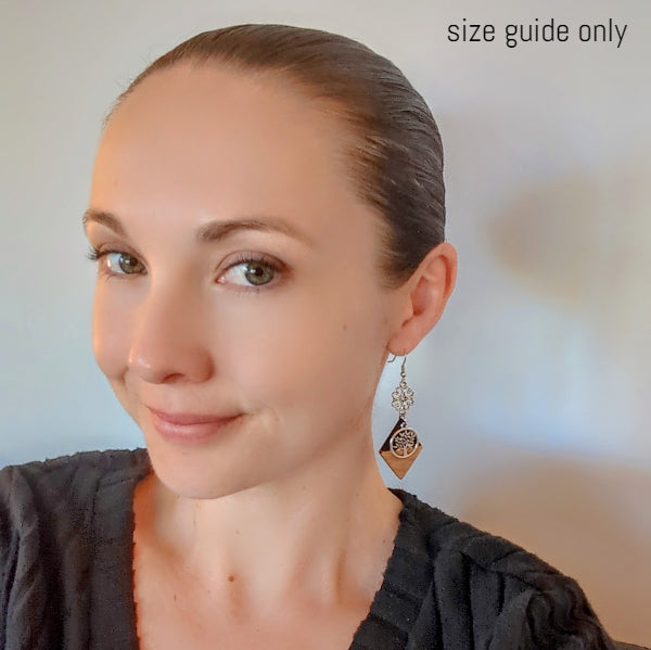 Women wearing long diamond shape earrings as a size guide.