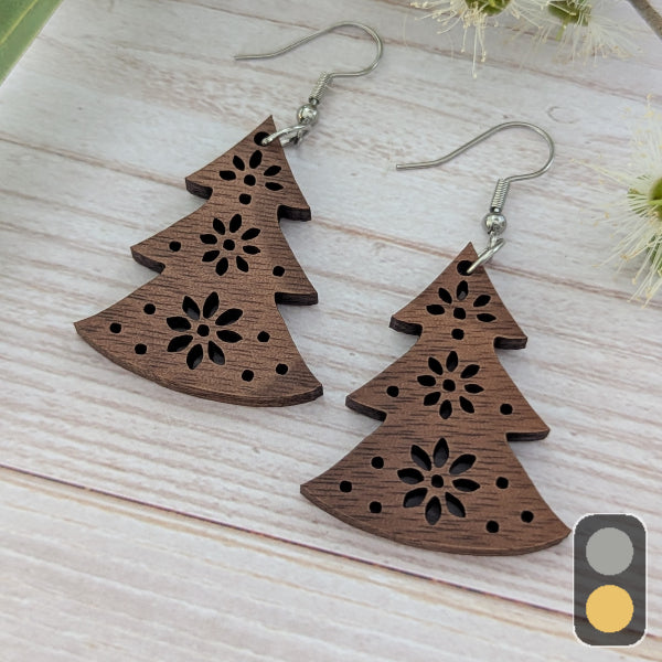 Wooden Christmas tree-shaped earrings on a light wooden surface. Stainless steel hooks.