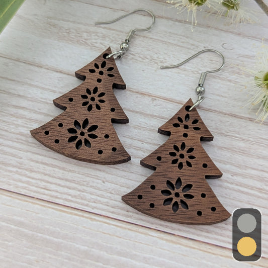 Wooden Christmas tree-shaped earrings on a light wooden surface. Stainless steel hooks.