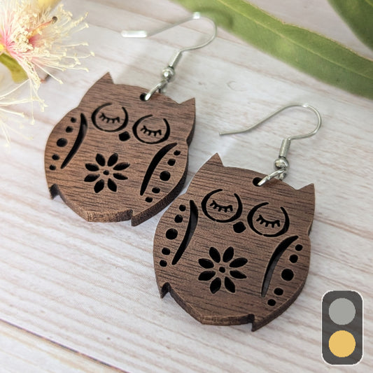 Wooden owl-shaped earrings on a light wooden surface. Stainless steel hooks.