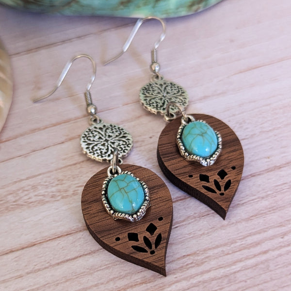 Wooden earrings with turquoise stones on a wooden surface