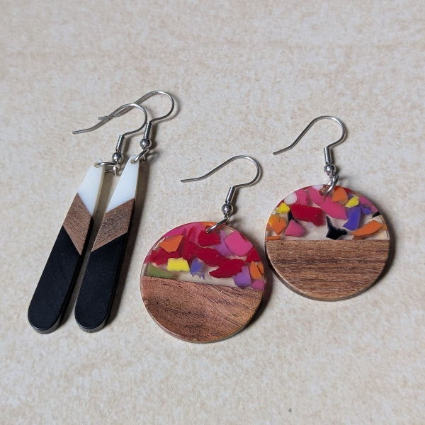 Two pairs of colourful earrings made from resin and wood on a beige background. Stainless steel hooks.