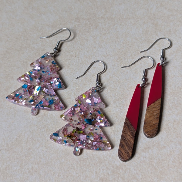 Two pairs of colourful earrings made from resin and wood on a beige background. Stainless steel hooks.