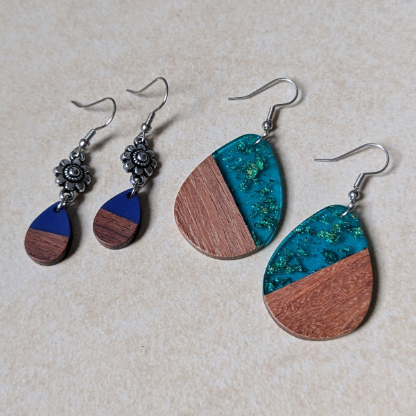 Two pairs of colourful earrings made from resin and wood on a beige background. Stainless steel hooks.