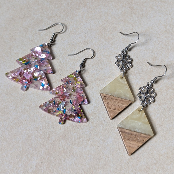 Two pairs of colourful earrings made from resin and wood on a beige background. Stainless steel hooks.