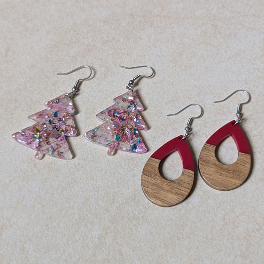 Two pairs of colourful earrings made from resin and wood on a beige background. Stainless steel hooks.