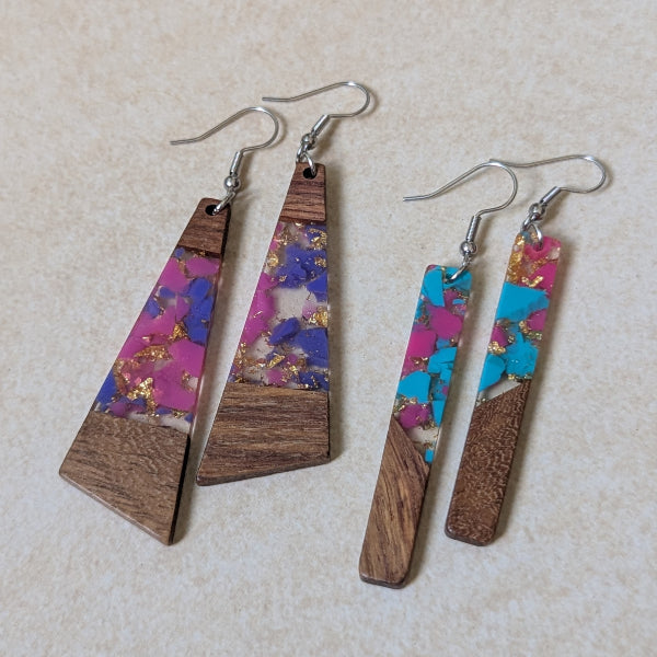 Two pairs of colourful earrings made from resin and wood on a beige background. Stainless steel hooks.