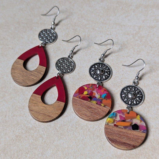 Two pairs of colourful earrings made from resin and wood on a beige background. Stainless steel hooks.