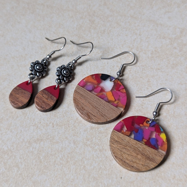 Two pairs of colourful earrings made from resin and wood on a beige background. Stainless steel hooks.