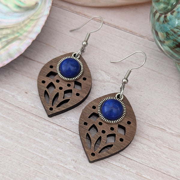 Wooden earrings with blue stone centres on a wooden surface. Stainless steel hooks.