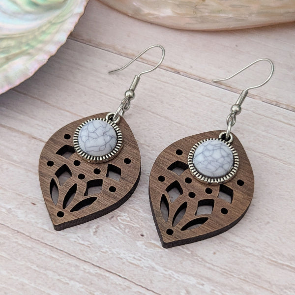 Wooden earrings with white stone centres on a wooden surface. Stainless steel hooks.