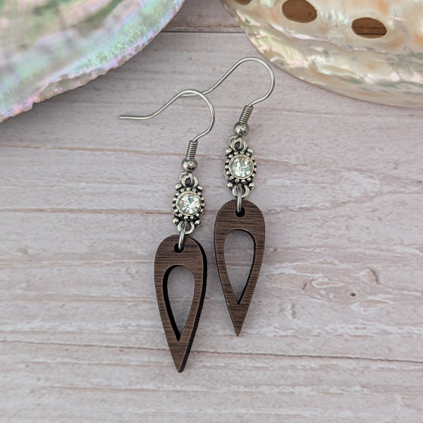 Wooden earrings with crystal connectors, light wood background. Stainless steel hooks.