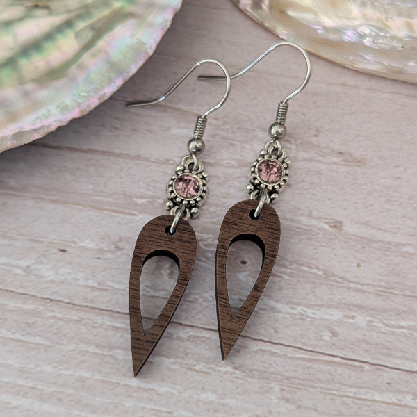 Wooden earrings with mauve crystal connectors, light wood background. Stainless steel hooks.