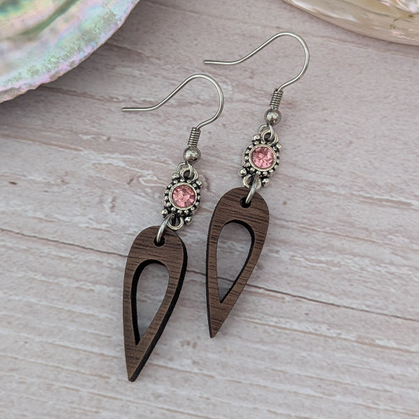 Wooden earrings with pink crystal connectors, light wood background. Stainless steel hooks.